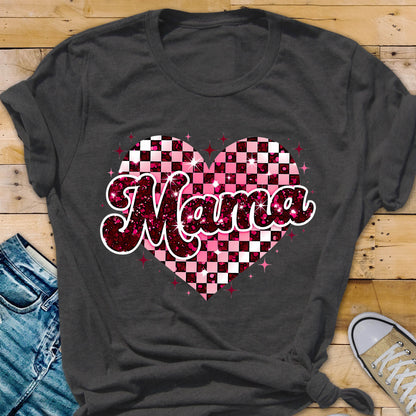 May include: A dark gray t-shirt with a pink and white checkered heart design. The word "Mama" is written in a pink glittery font over the heart.