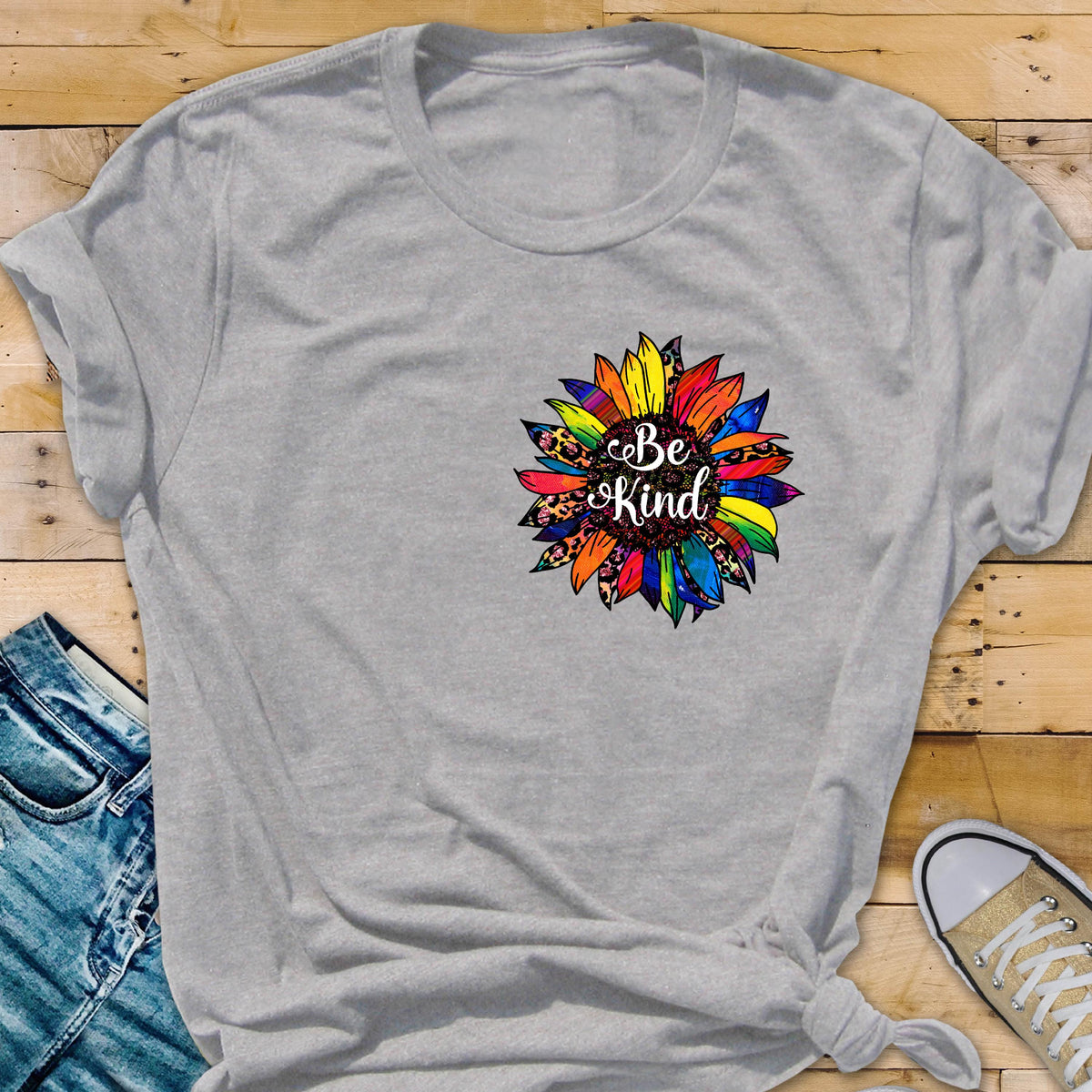 May include: Gray t-shirt with a colorful sunflower design and the text "Be Kind" in the center.