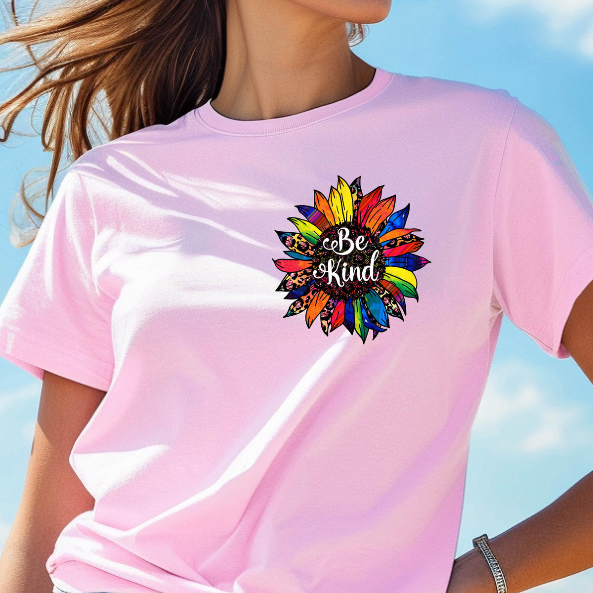May include: Pink t-shirt with a colorful sunflower graphic and the text "Be Kind" in the center.