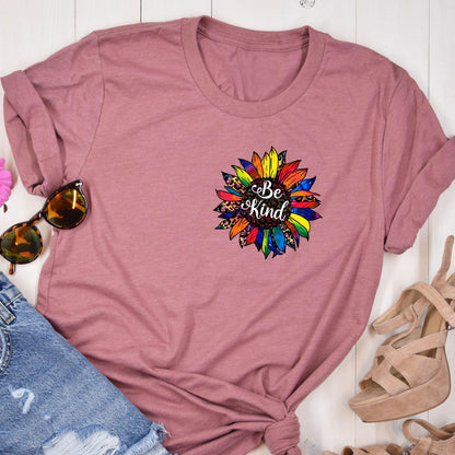 May include: A mauve t-shirt with a colorful sunflower graphic and the text "Be Kind" in white.