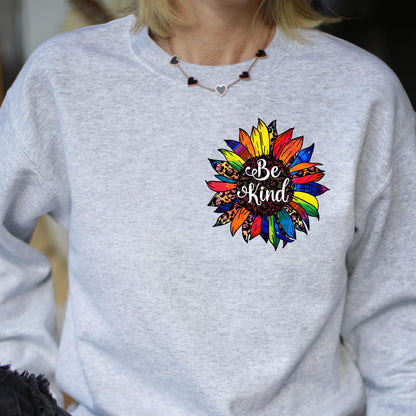 May include: A gray sweatshirt with a colorful sunflower design and the text "Be Kind" in the center.