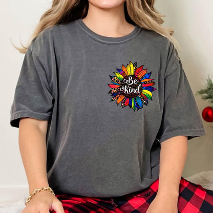 May include: A charcoal gray t-shirt featuring a colorful sunflower design. The sunflower has rainbow-colored petals and a leopard print center, with the words "Be Kind" in the center.