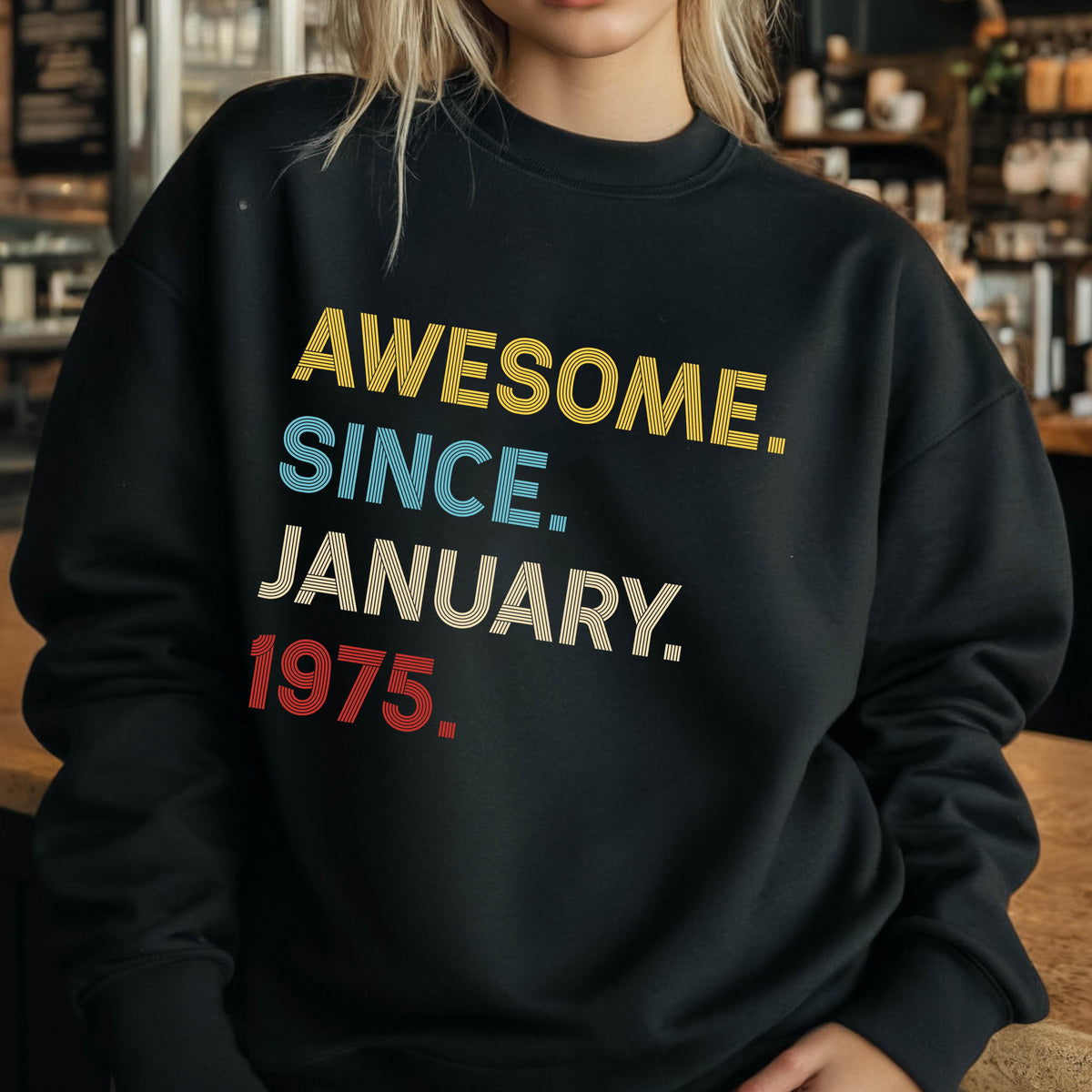 May include: Black sweatshirt with the text "AWESOME. SINCE. JANUARY. 1975." in yellow, blue, cream, and red block letters. The sweatshirt has a crew neck and long sleeves.
