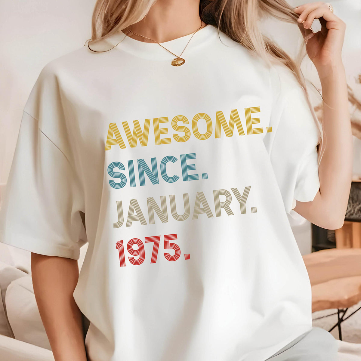 May include: A white short-sleeved t-shirt featuring the text AWESOME. SINCE. JANUARY. 1975. printed in a stacked design. The words are rendered in a striped font with yellow for AWESOME, blue for SINCE, beige for JANUARY, and red for 1975.