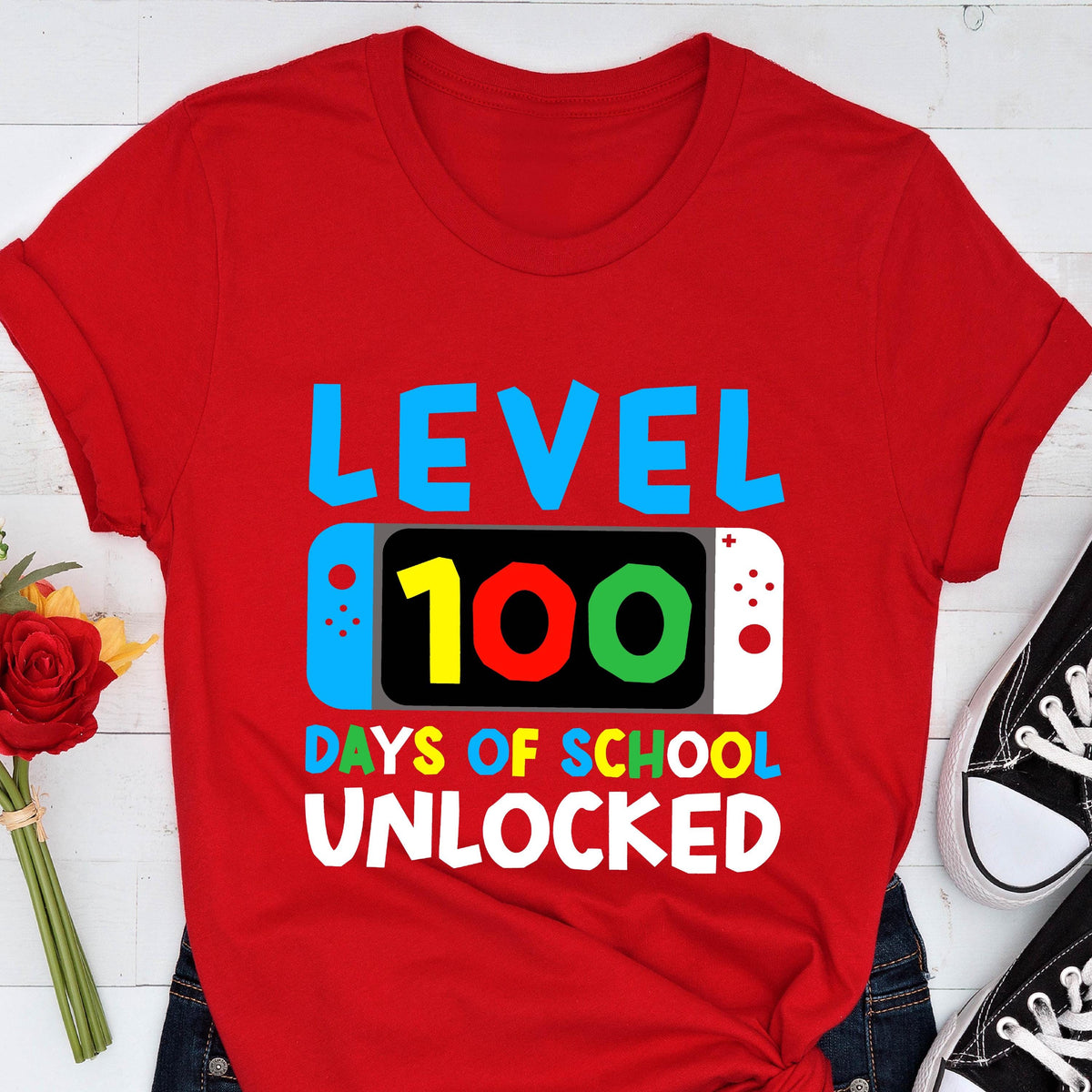 May include: Red t-shirt with a graphic of a video game controller with the text "Level 100 Days of School Unlocked".