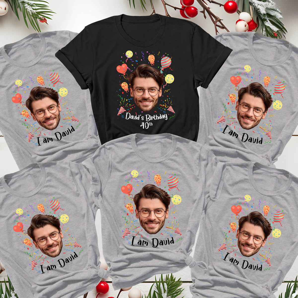 May include: A collection of five short-sleeved t-shirts, one black and four heather gray, each featuring a printed portrait of a man with glasses, colorful balloons, and confetti. The black shirt reads David's Birthday 40th, while the others read I am David.