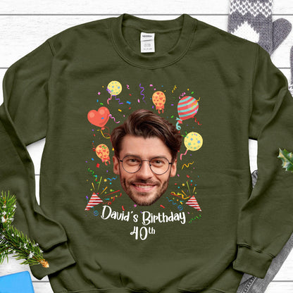 May include: A green sweatshirt with a personalized birthday design. The design features a photo of a person's face surrounded by colorful balloons and confetti. The text "David's Birthday 40th" is printed below the photo.