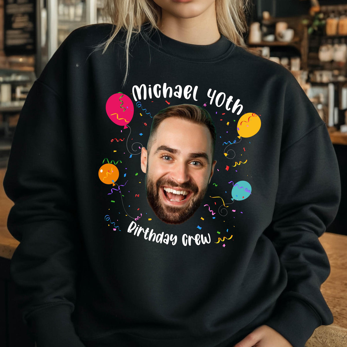 May include: Black sweatshirt with a colorful birthday design. The design features a person's face, balloons, confetti, and the text "Michael 40th Birthday Crew".