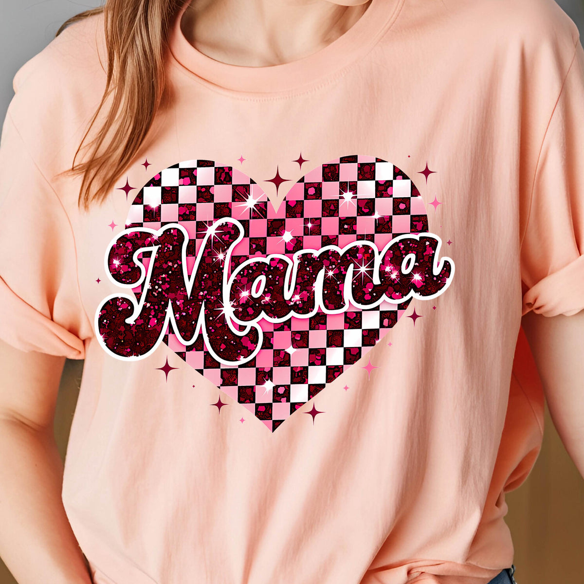 May include: Pink t-shirt with a pink and black checkered heart design and the word "Mama" in a glittery pink font.