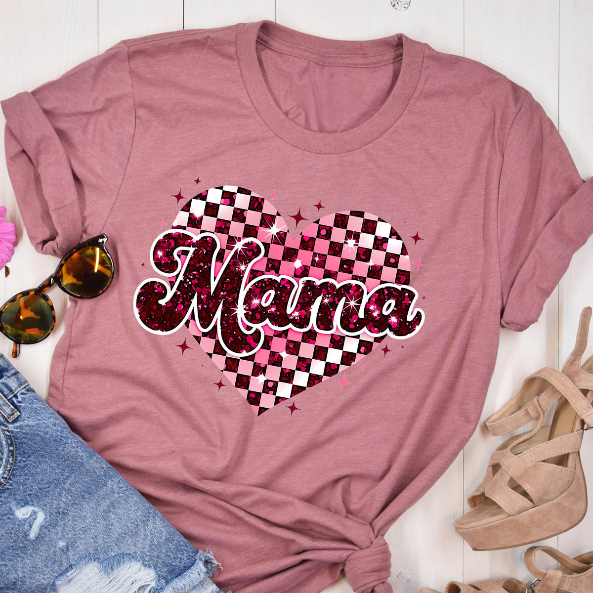 May include: Pink t-shirt with a pink and white checkered heart design and the word "Mama" in a glittery font.