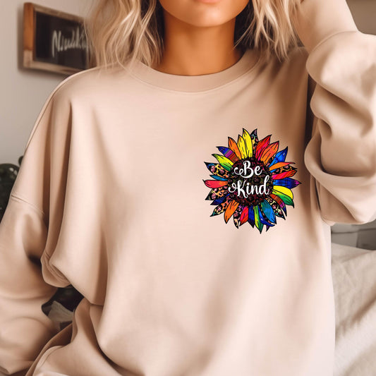 May include: A beige sweatshirt with a colorful sunflower graphic and the text "Be Kind" in the center.
