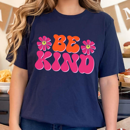 May include: A navy blue t-shirt with a pink and orange graphic that says "BE KIND" with two pink flowers with yellow centers on either side of the text.