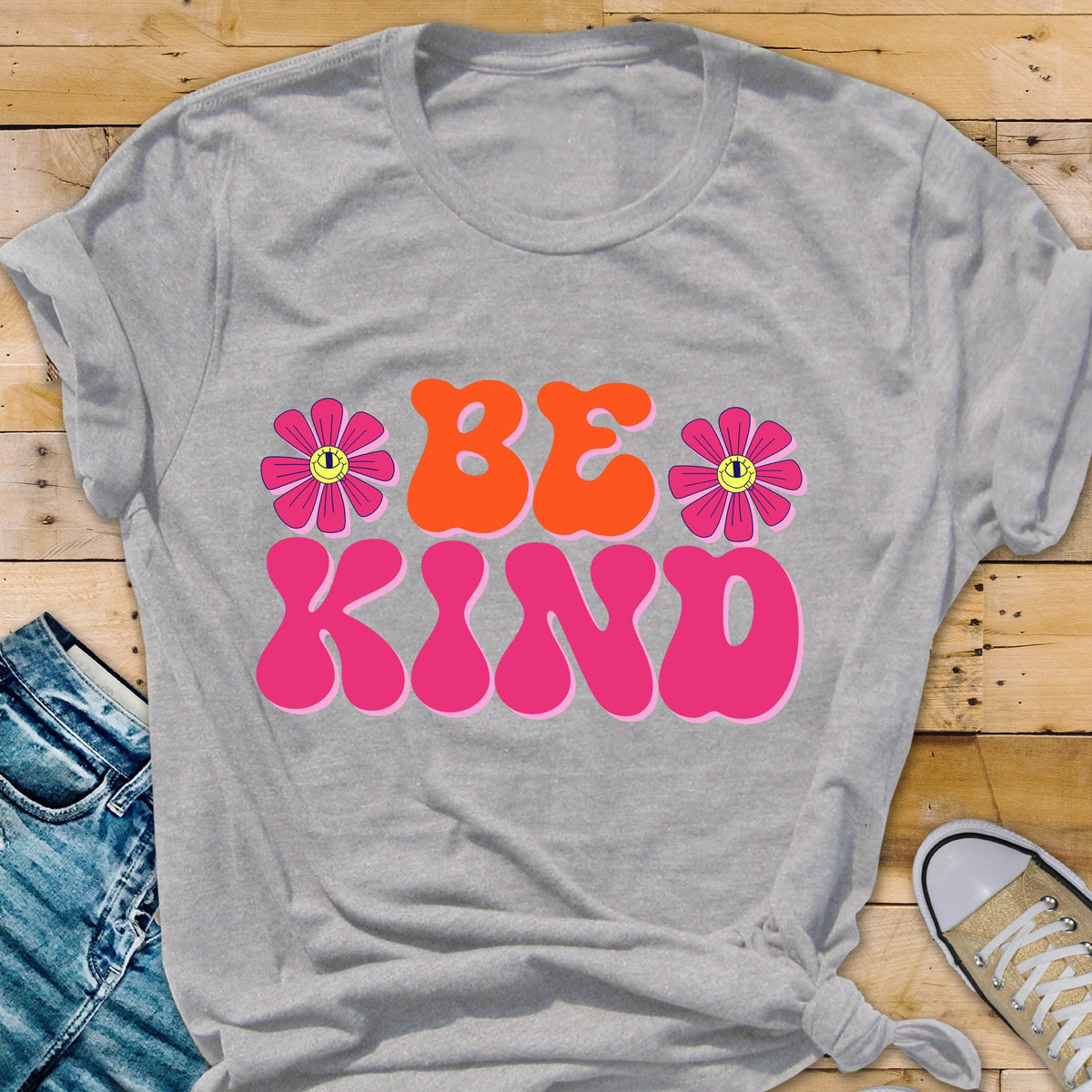 May include: Gray t-shirt with a pink and orange graphic that says "BE KIND" with two pink flowers with yellow smiley faces on them.