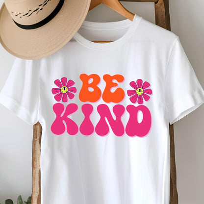 May include: White t-shirt with a pink and orange graphic that says "BE KIND" with two pink flowers with yellow smiley faces on them.