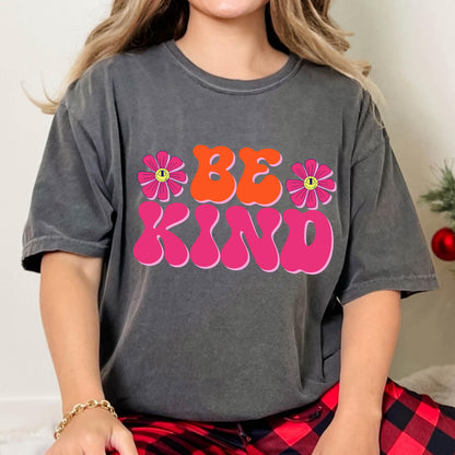 May include: A gray t-shirt with a pink and orange graphic that says "BE KIND" with two pink flowers with yellow smiley faces on them.