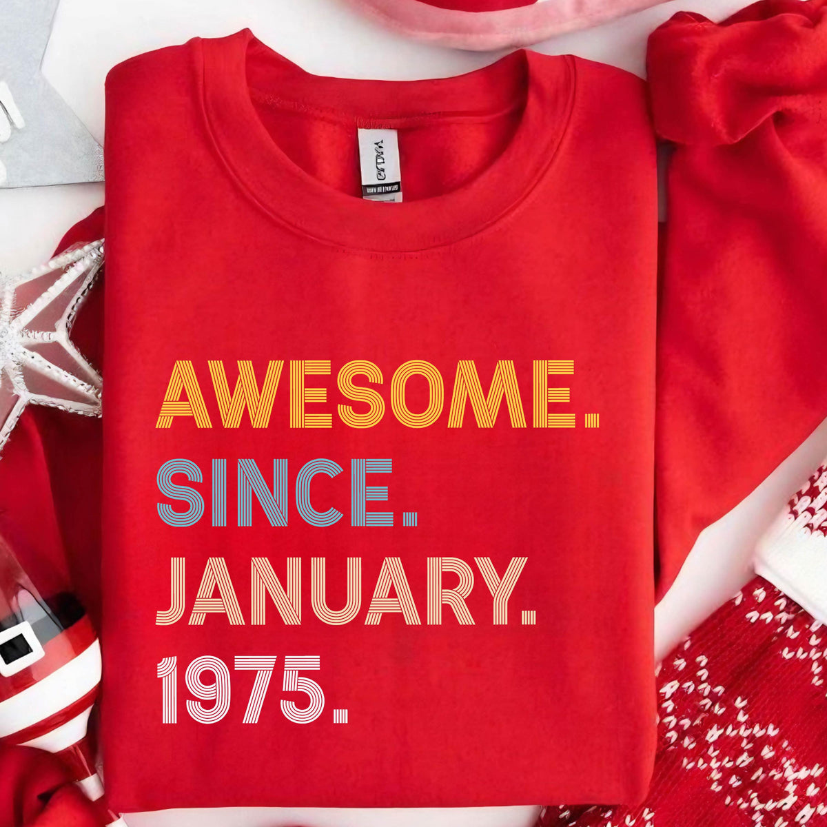 May include: A red sweatshirt with the text "AWESOME. SINCE. JANUARY. 1975." in yellow, blue, and white. The sweatshirt is a crew neck style.
