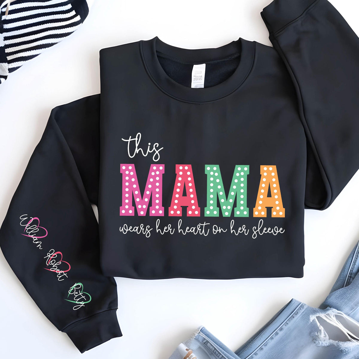 May include: Black sweatshirt with the text "This Mama wears her heart on her sleeve" in colorful letters with white polka dots. The sleeves have the names "William", "Robert", and "Betty" written in cursive.