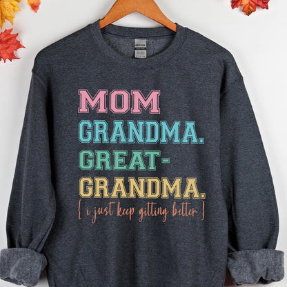 May include: A dark gray sweatshirt with the text "MOM GRANDMA. GREAT-GRANDMA. (I just keep getting better)" printed in rainbow colors.