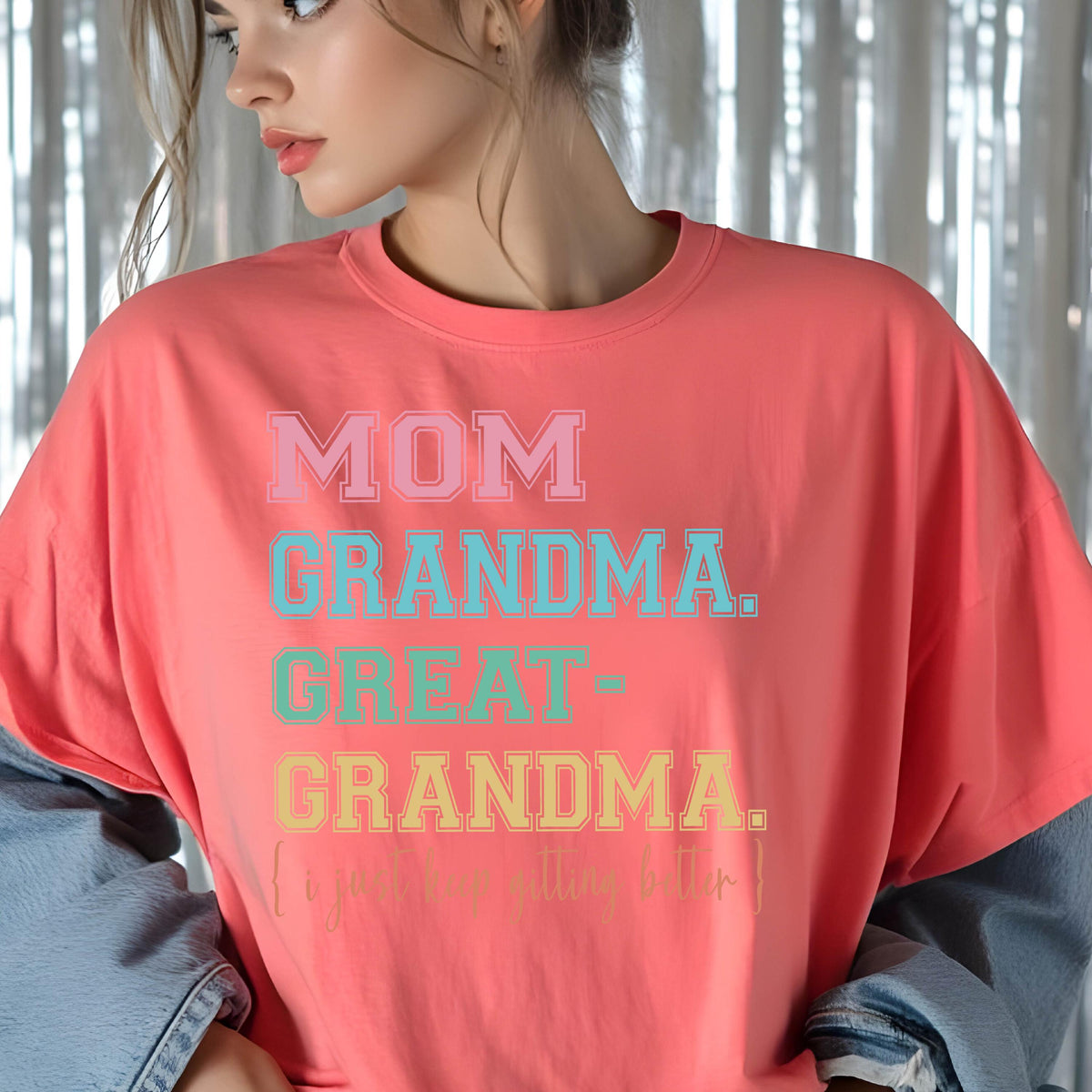 May include: A coral pink t-shirt with the text "MOM GRANDMA. GREAT-GRANDMA. [I'm getting better]" printed in various colors.