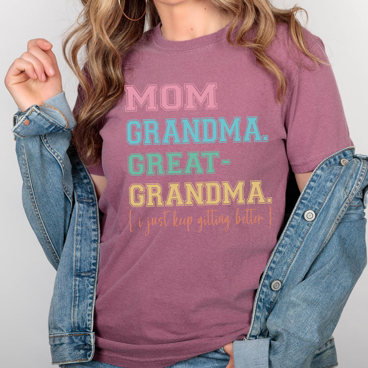 May include: A mauve t-shirt with the text "MOM GRANDMA. GREAT-GRANDMA. I just keep getting better." in colorful block letters.