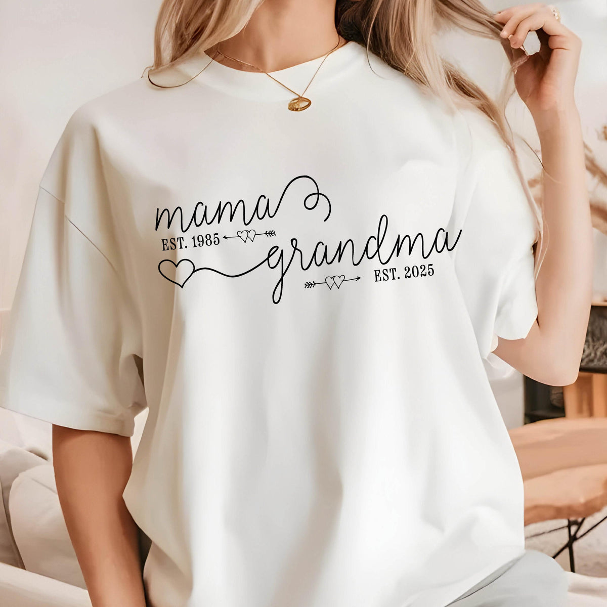 May include: White t-shirt with black text that reads "mama est. 1985 grandma est. 2025" with a heart and arrow design.