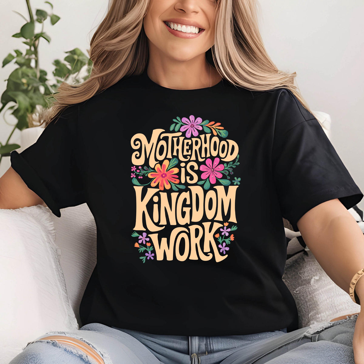 May include: Black t-shirt with a floral design and the text "Motherhood is Kingdom Work" in a yellow font.