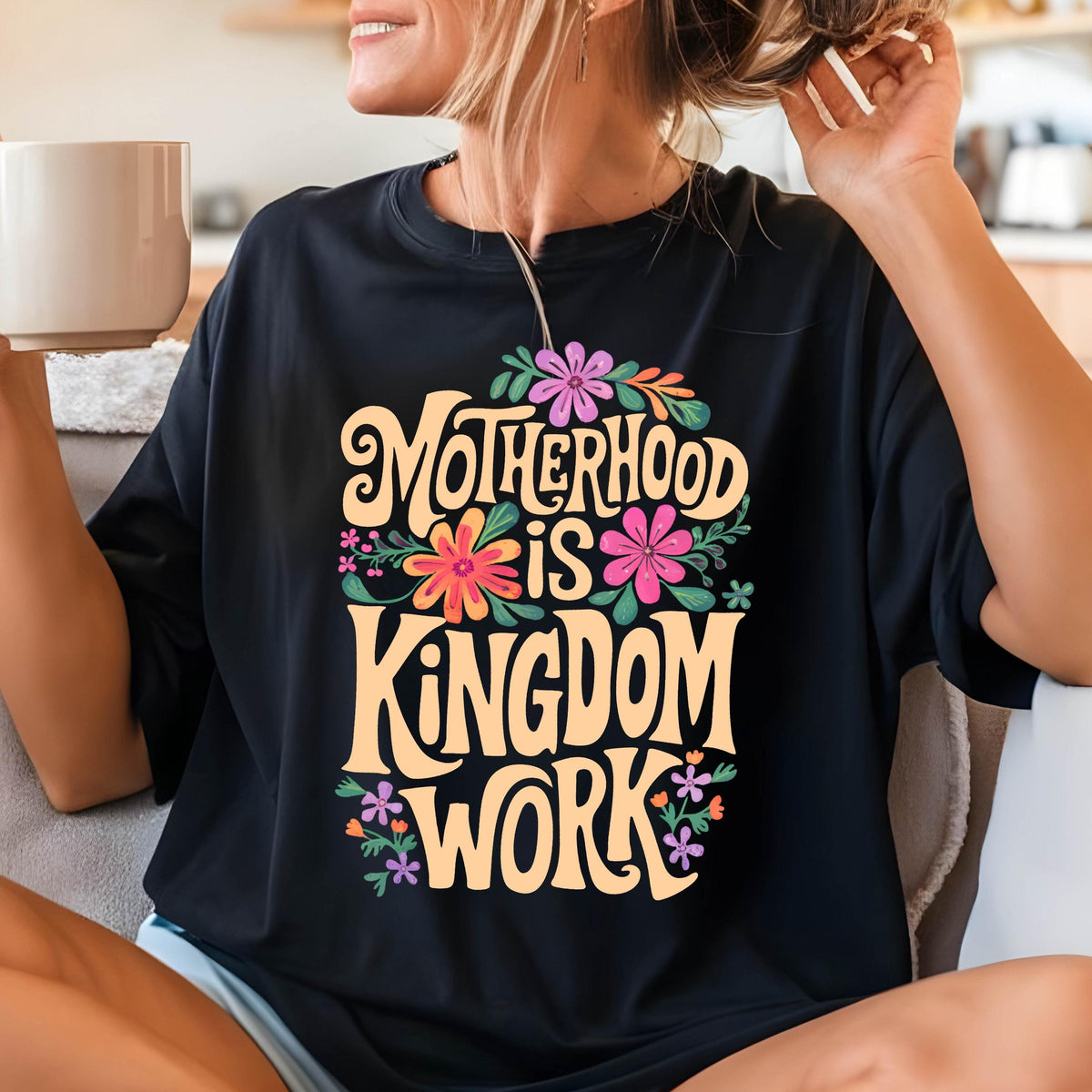 May include: Black t-shirt with a floral design and the text "Motherhood is Kingdom Work" in a yellow font.
