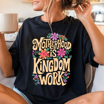 May include: Black t-shirt with a floral design and the text "Motherhood is Kingdom Work" in a yellow font.