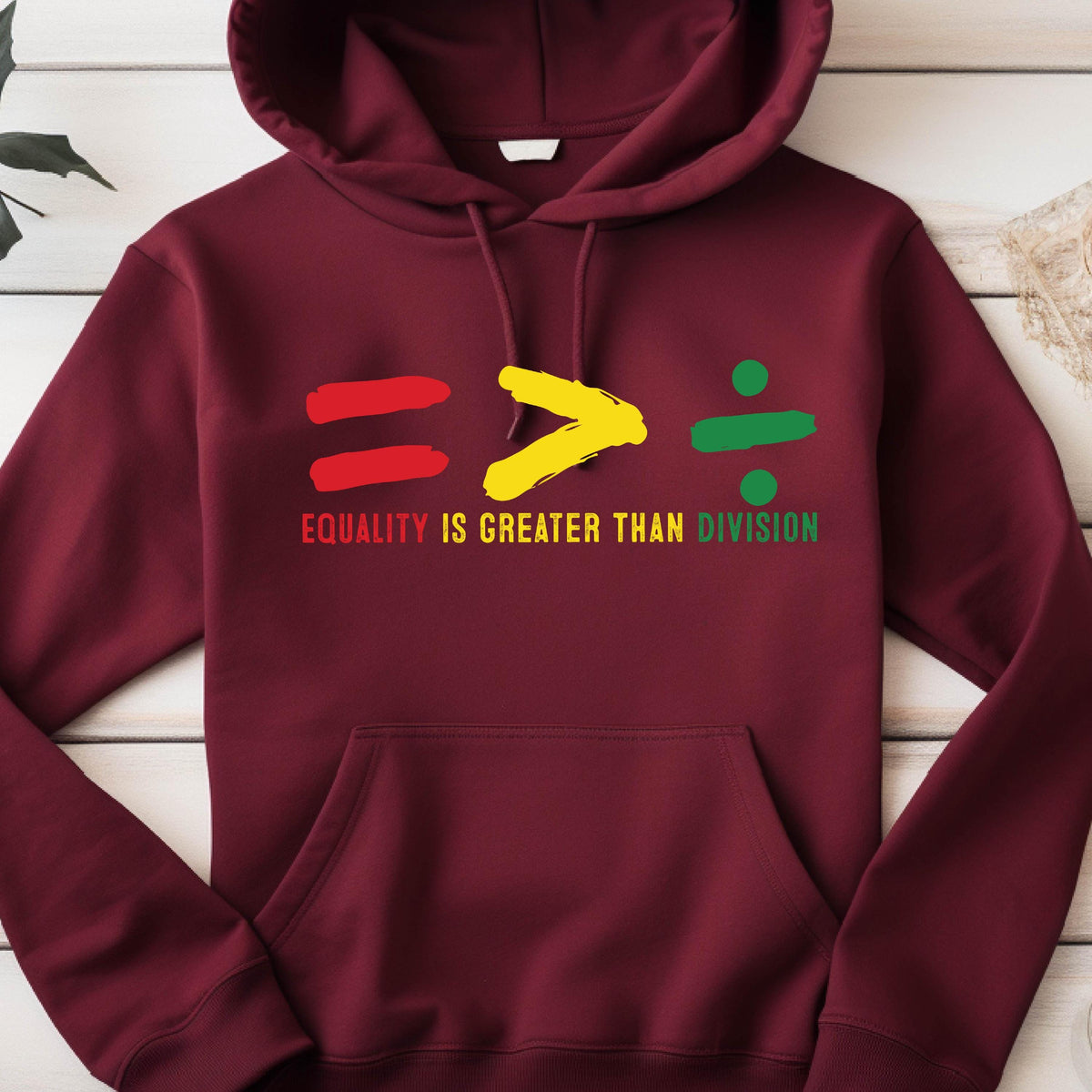 May include: A maroon hoodie with a graphic of an equals sign, a greater than sign, and a division sign. The graphic is in red, yellow, and green. The text "Equality is greater than division" is printed below the graphic.