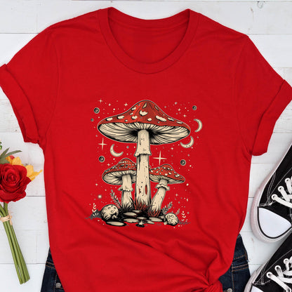 May include: Red and white mushroom graphic on a red t-shirt. The mushrooms are surrounded by stars and crescent moons.