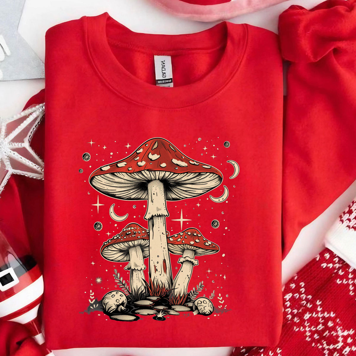 May include: Red sweatshirt with a graphic of three red and white mushrooms with a starry night sky background.