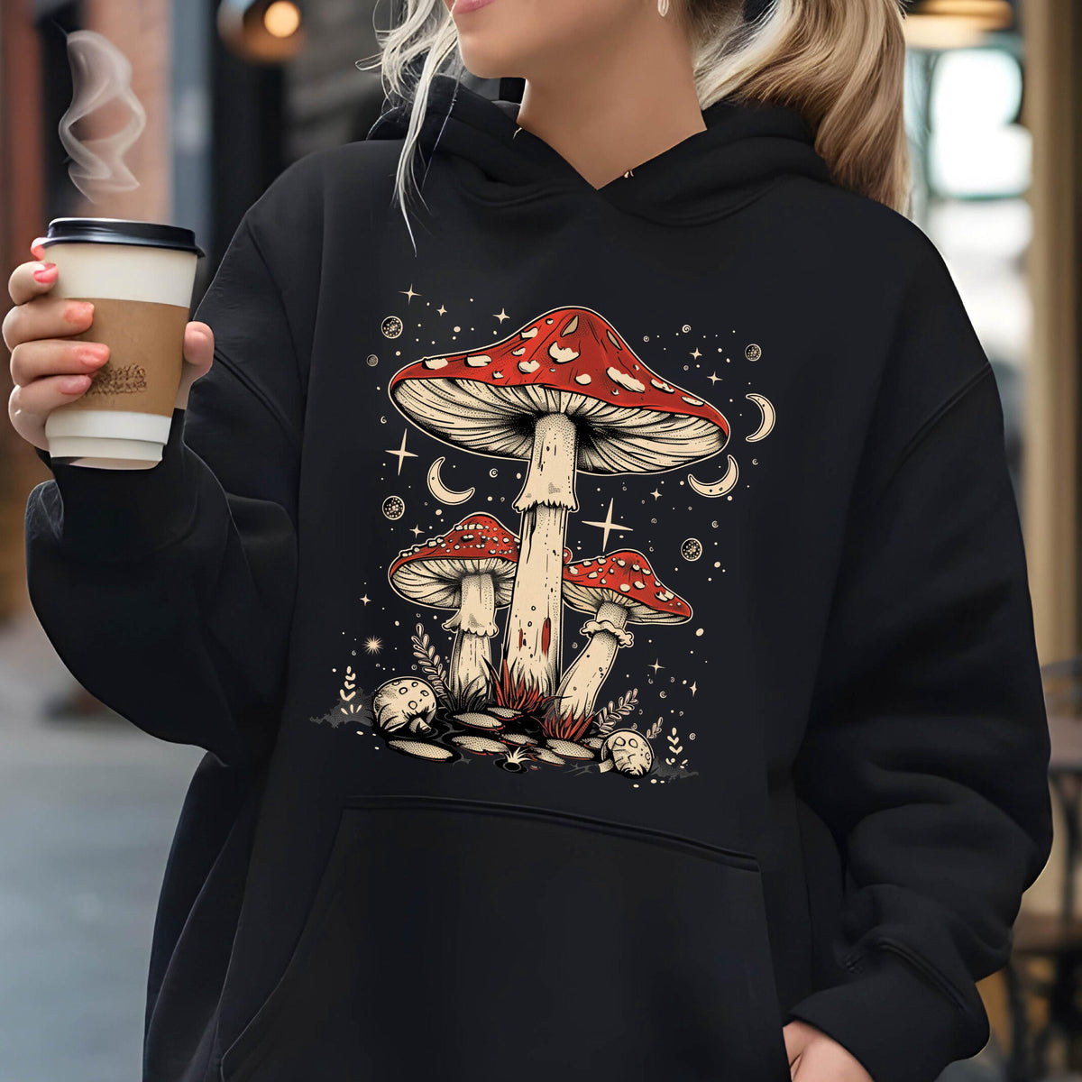 May include: Black hoodie with a graphic of three red and white mushrooms with white stems against a dark blue background with white stars and moons. The text "Shroom Queens" is printed on the hoodie.