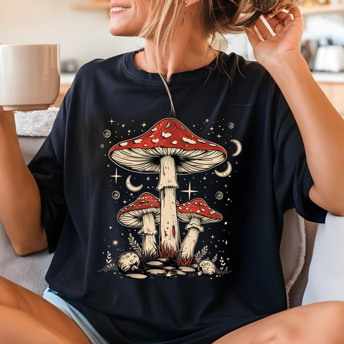 May include: Black t-shirt with a graphic of three red and white mushrooms with white stems against a dark blue background with white stars and crescent moons.
