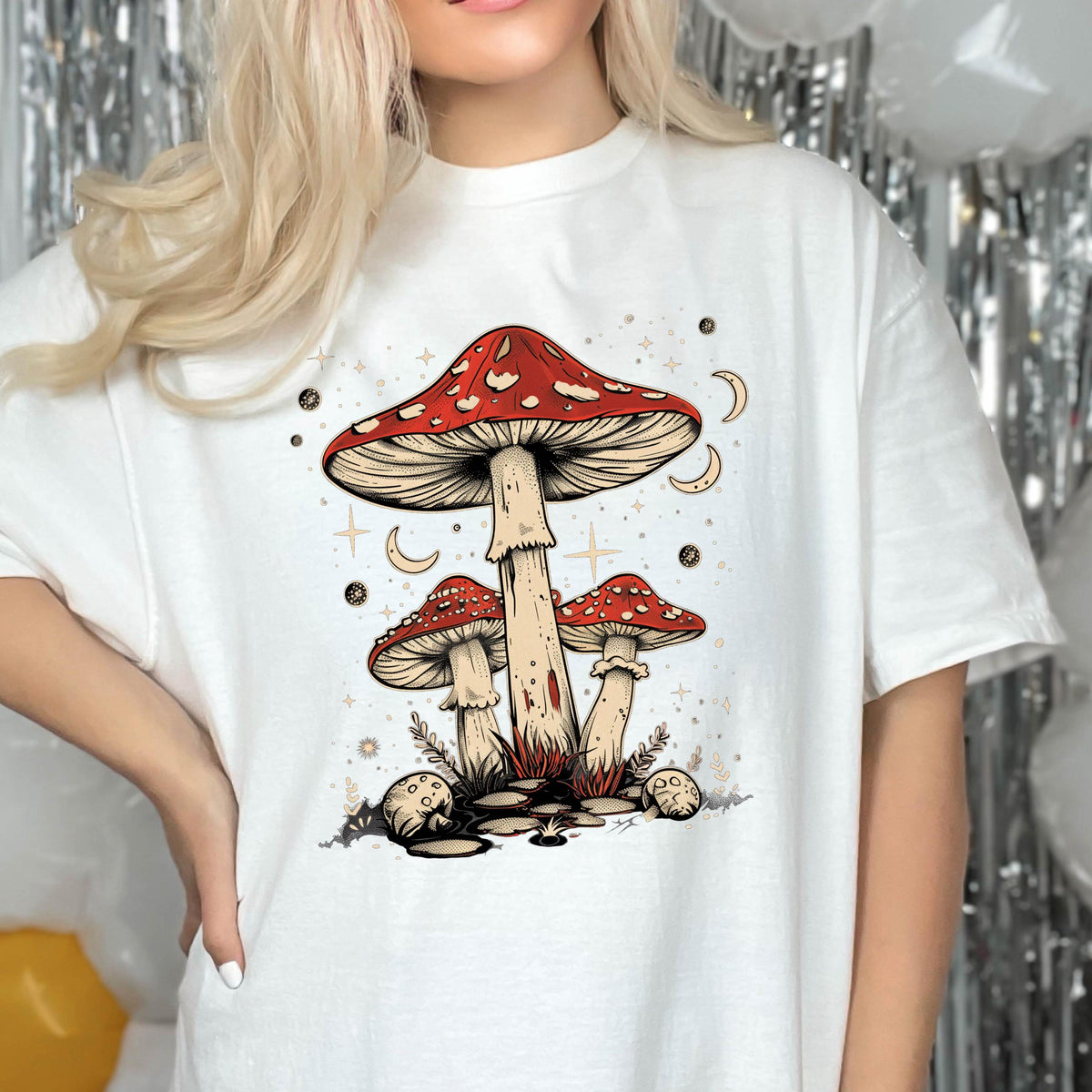 May include: White t-shirt with a graphic of red and white mushrooms with a starry night background.