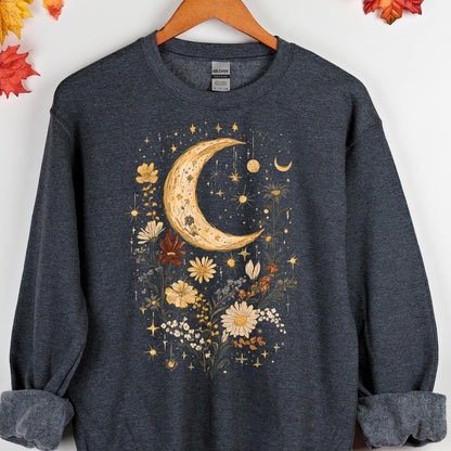 May include: A dark heather gray long-sleeve crewneck sweatshirt featuring a central graphic print of a large yellow crescent moon surrounded by various wildflowers, small stars, and celestial elements in shades of yellow, orange, and white.