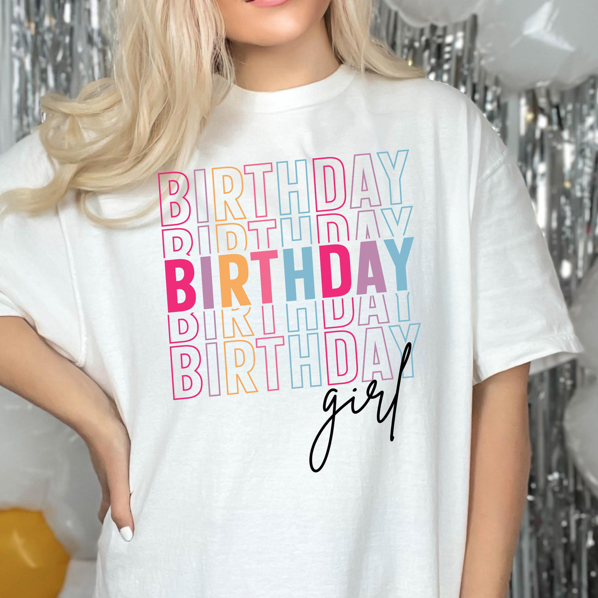 May include: White t-shirt with the text "Birthday girl" in rainbow colors. The word "Birthday" is repeated multiple times in a stacked design.