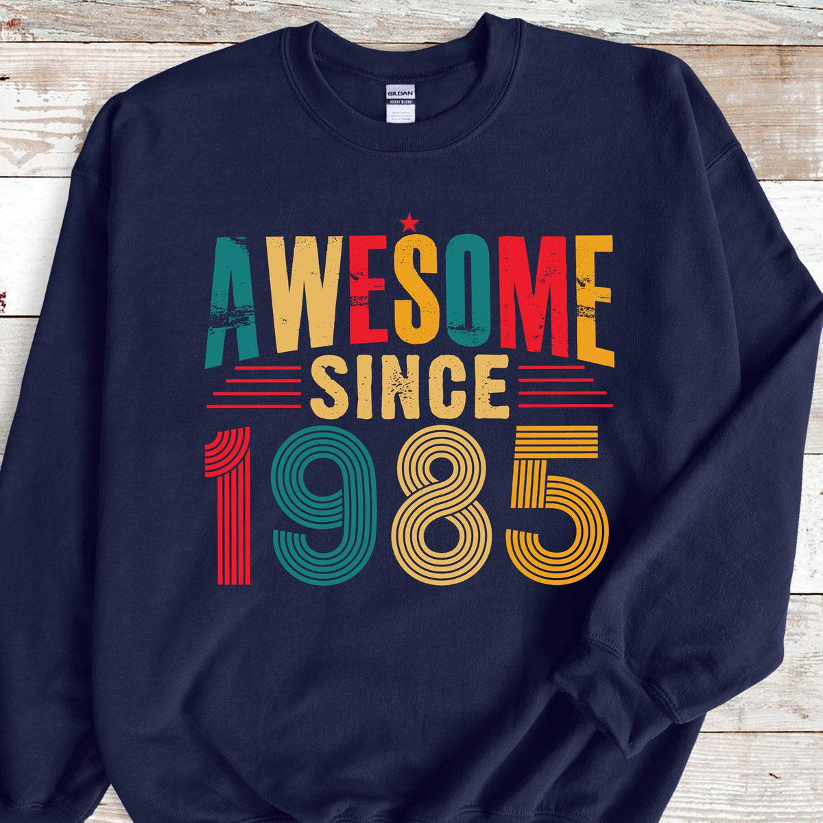 May include: Navy blue sweatshirt with a vintage-style graphic that reads "Awesome Since 1985". The graphic is in red, yellow, green, and blue.