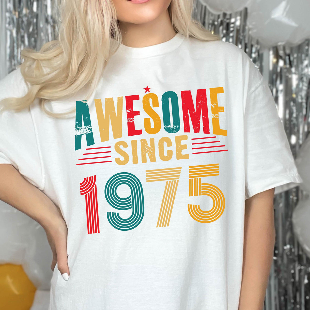 May include: White t-shirt with a vintage-style graphic that says "Awesome Since 1975" in red, yellow, green, and blue.
