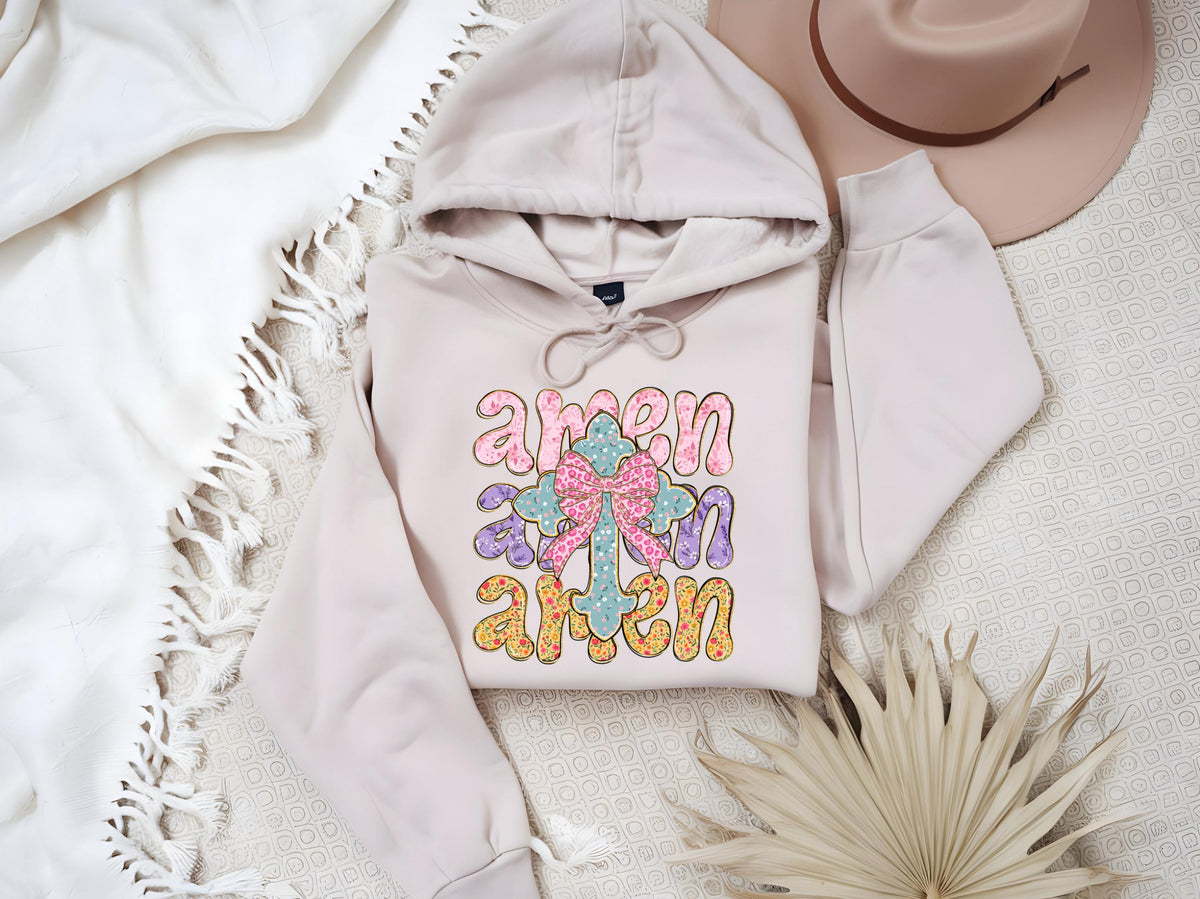 May include: A light pink hoodie with a cross and the word "amen" repeated three times in a colorful, retro font.