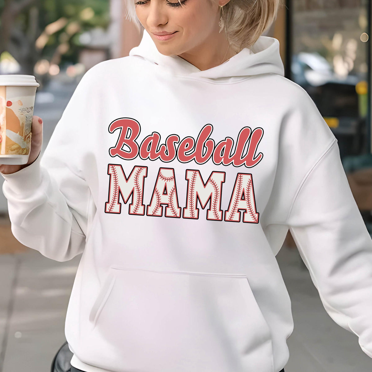 May include: A white long-sleeve hooded sweatshirt featuring the text "Baseball MAMA" printed on the front. The word "Baseball" is in a red script font, and "MAMA" is in a block font with a white and red baseball stitch pattern.
