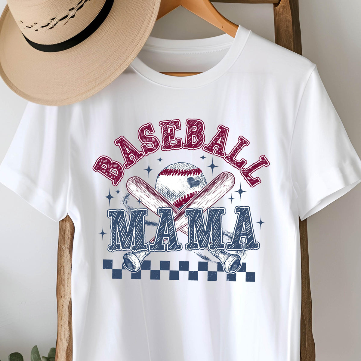 May include: White t-shirt with a blue and red graphic design of baseball bats and a baseball with the text "Baseball Mama" in blue and red.