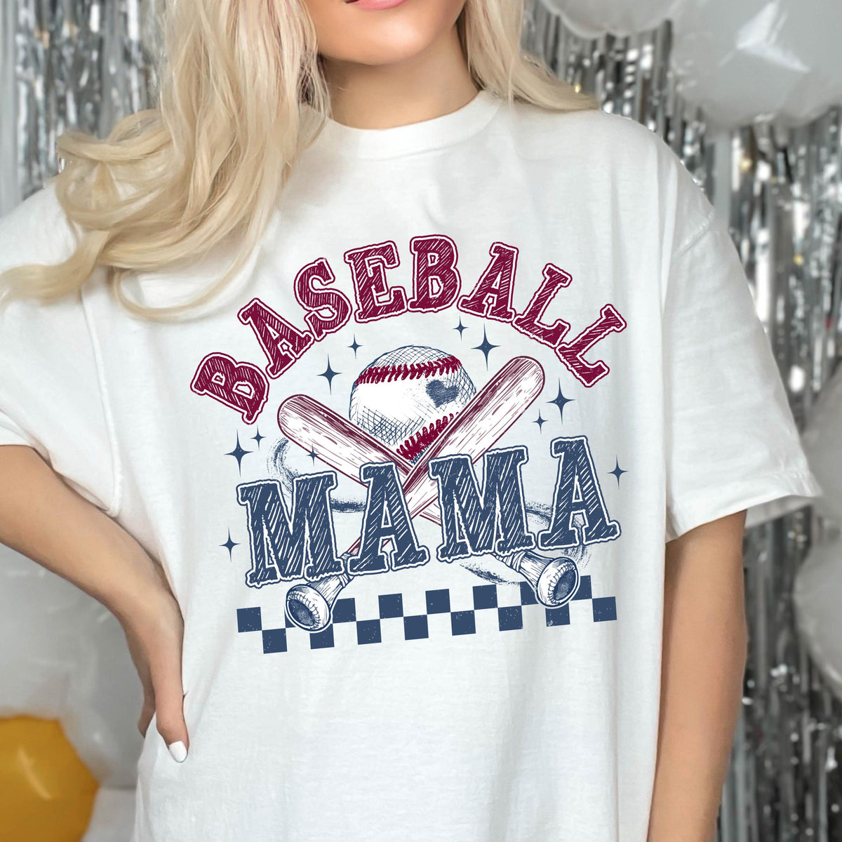 May include: White t-shirt with a baseball-themed graphic. The graphic features a baseball, two crossed bats, and the text "Baseball Mama".