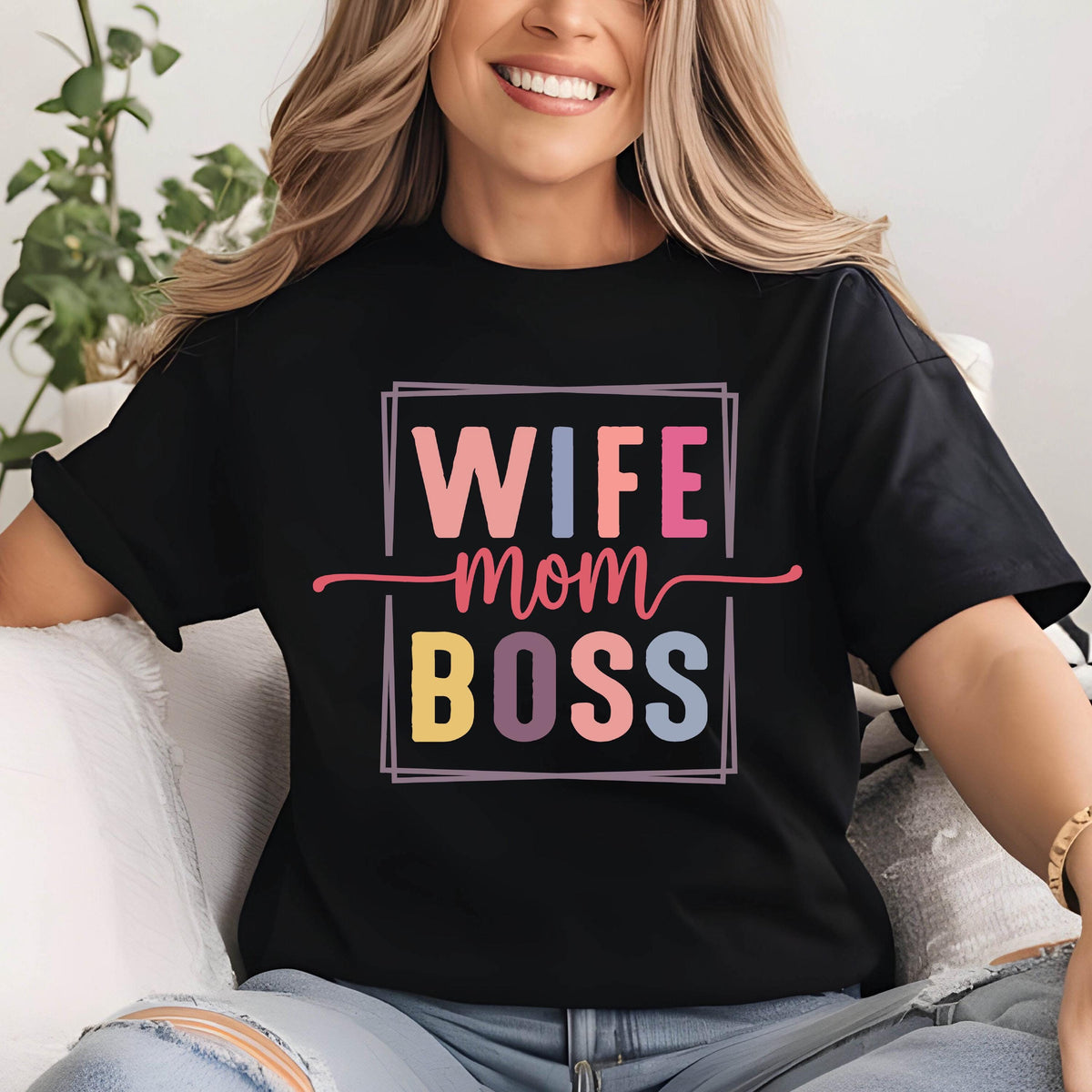 May include: Black t-shirt with the words "WIFE mom BOSS" in a colorful, rectangular design. The text is in pink, blue, yellow, and purple. The shirt is a casual style.