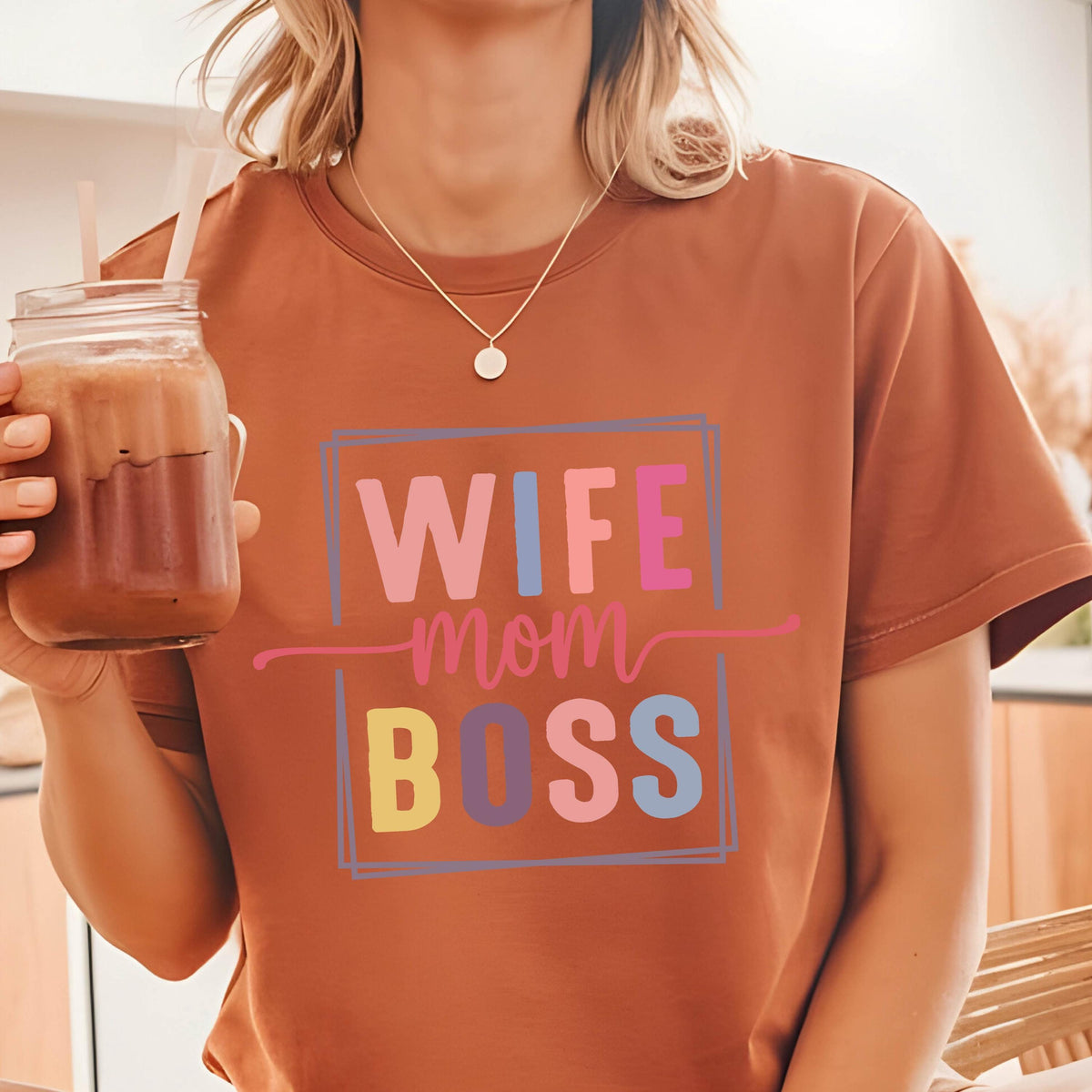 May include: A brown t-shirt with the text "WIFE MOM BOSS" in a colorful block font.