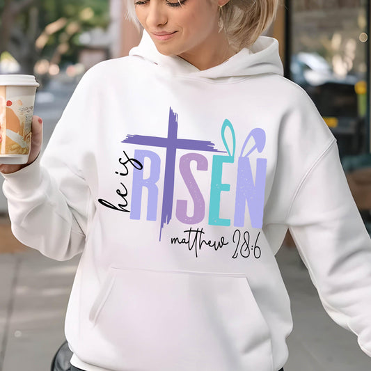 May include: White hoodie with a purple, blue, and pink graphic that says "He is Risen" with a cross and bunny ears. The text "Matthew 28:6" is below the graphic.