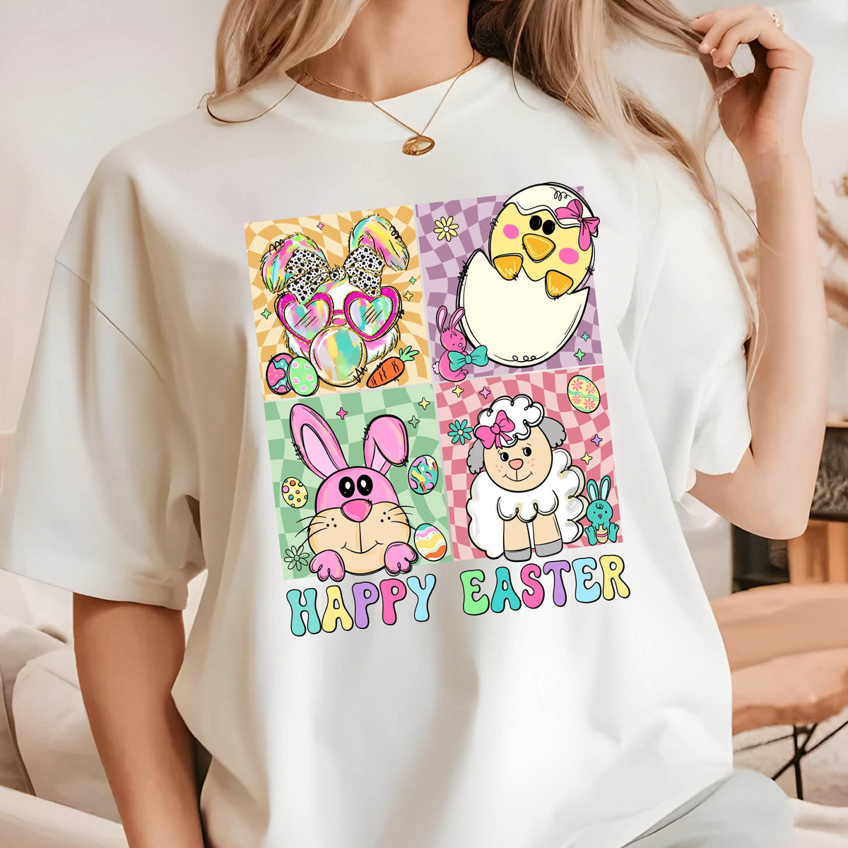 May include: White t-shirt with a colorful graphic of a bunny, chick, lamb, and eggs. The graphic is surrounded by a checkered pattern and the text "Happy Easter".
