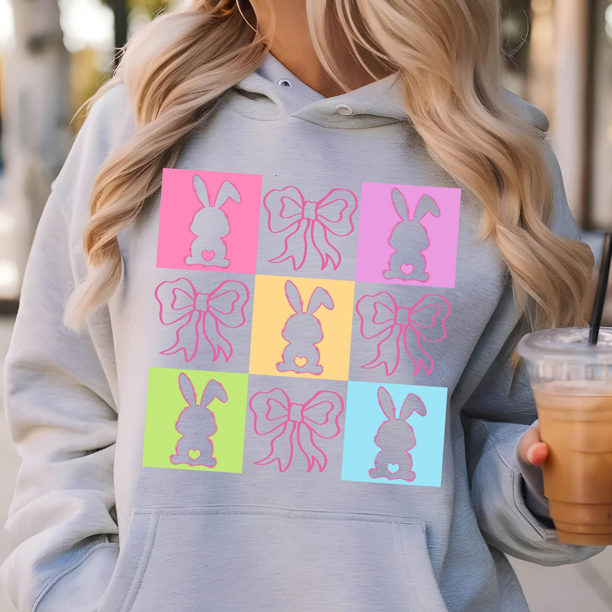 May include: A gray hoodie with a colorful design of bunnies and bows. The design is in a grid pattern with each square having a different color.