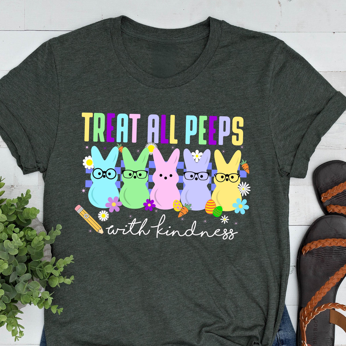May include: A dark grey t-shirt with a graphic of five pastel-colored peeps wearing glasses and the text "Treat all peeps with kindness".