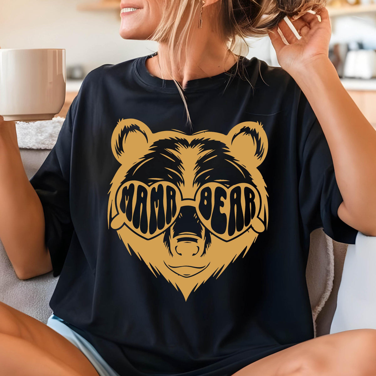 May include: Black t-shirt with a brown bear wearing heart-shaped sunglasses that say "Mama Bear".