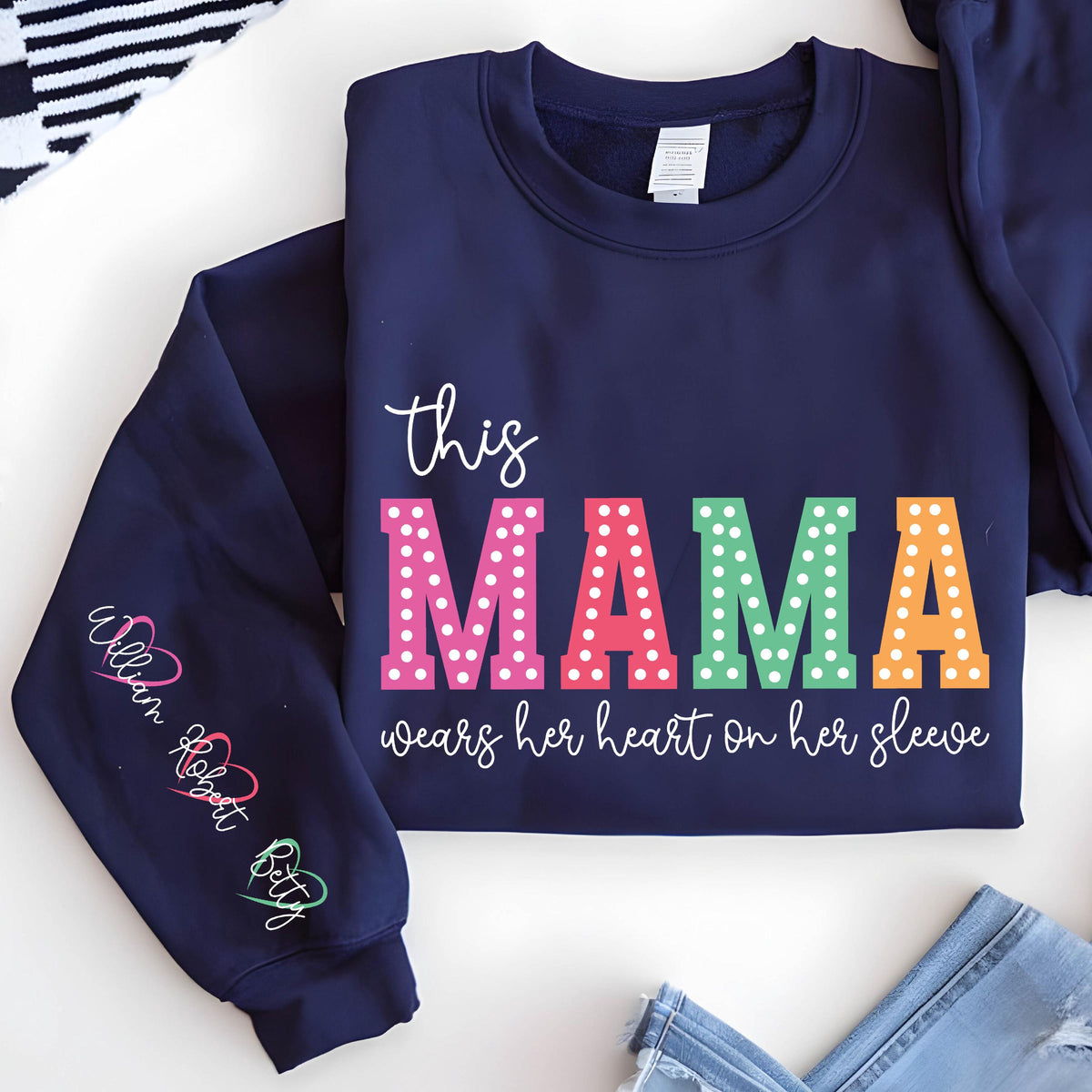 May include: Navy blue sweatshirt with the text "this mama wears her heart on her sleeve" in colorful letters with white polka dots. The words "William Robert Betty" are written on the left sleeve.